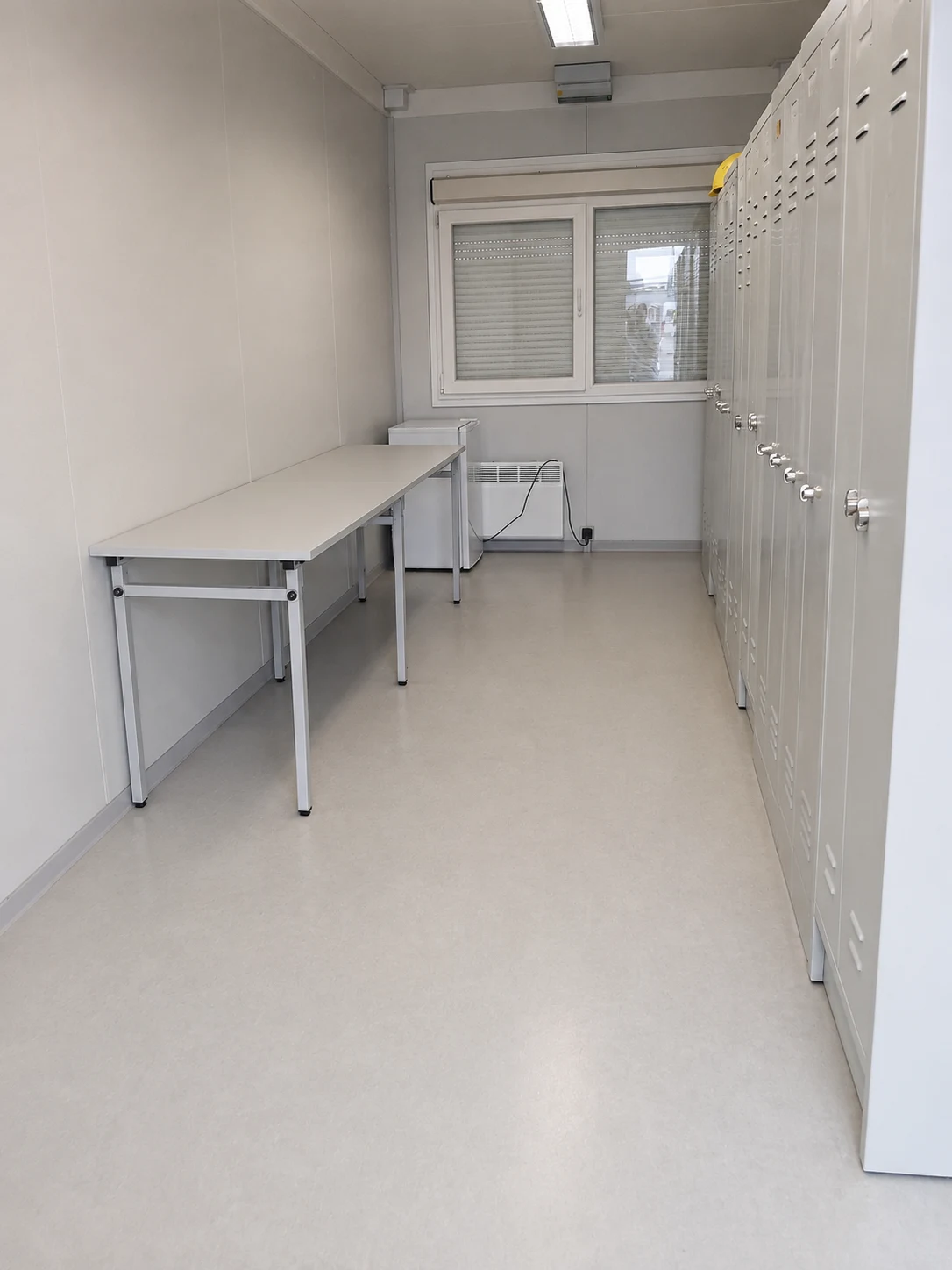 Gereinigter Umkleide- und Aufenthaltscontainer mit Spindreihe und Tisch